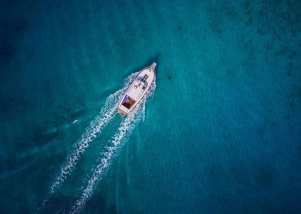 Aerial photo of a vintage wooden boat in coral sea. 