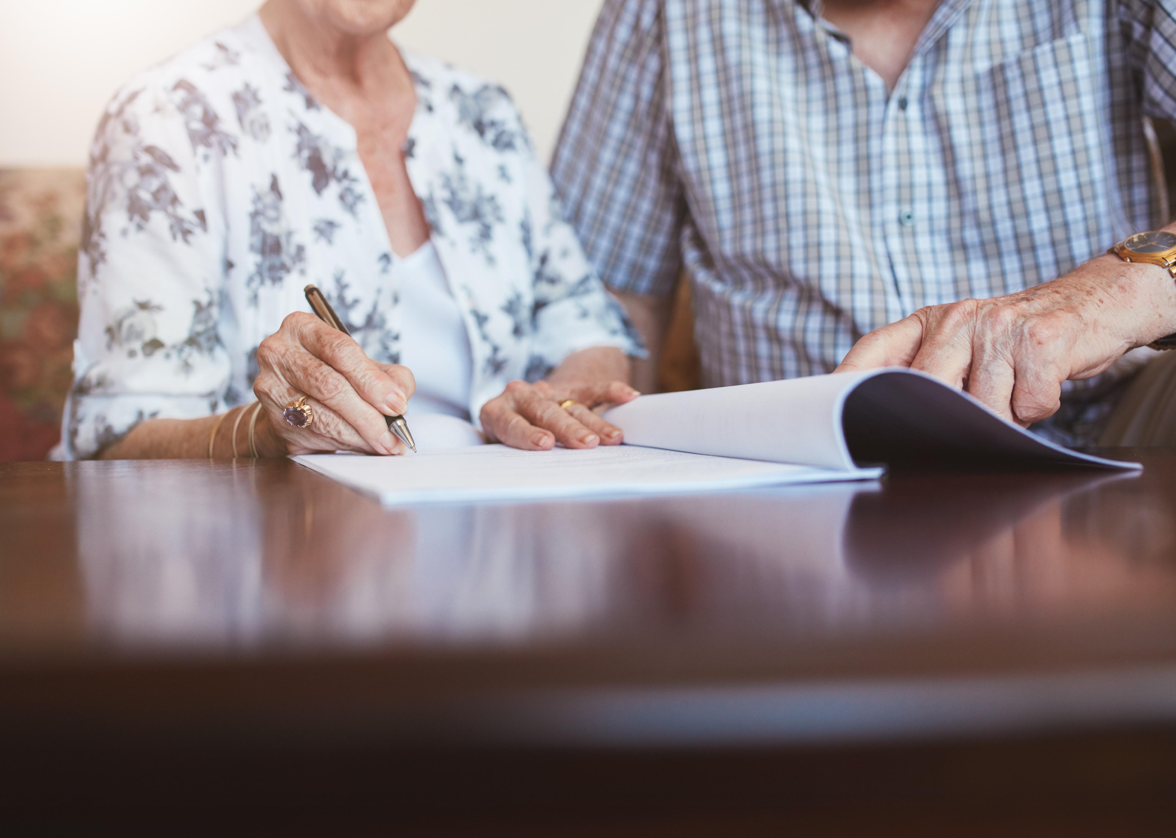 Close up shot of a person signing a document.