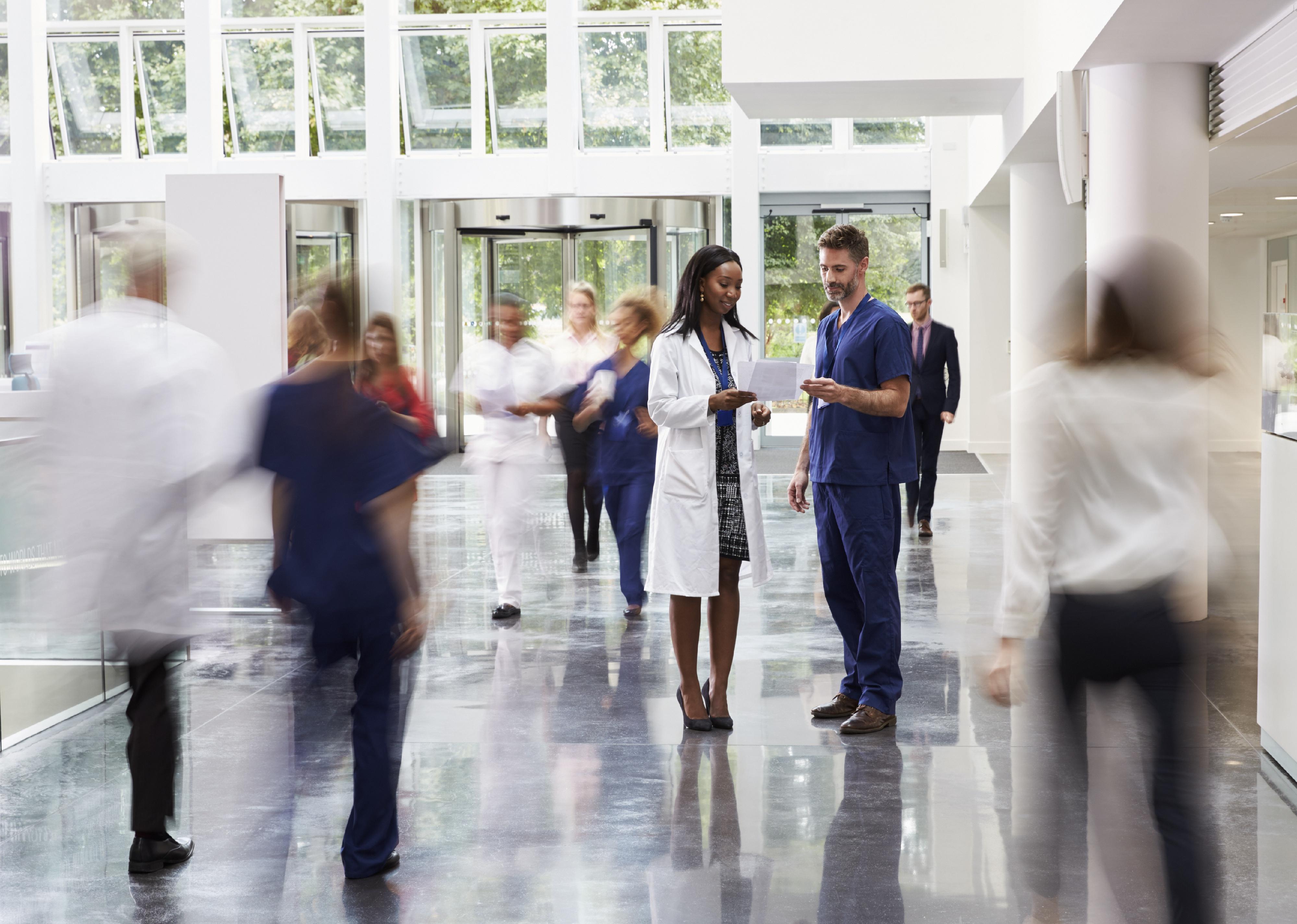 Staff in a busy lobby of modern hospital.