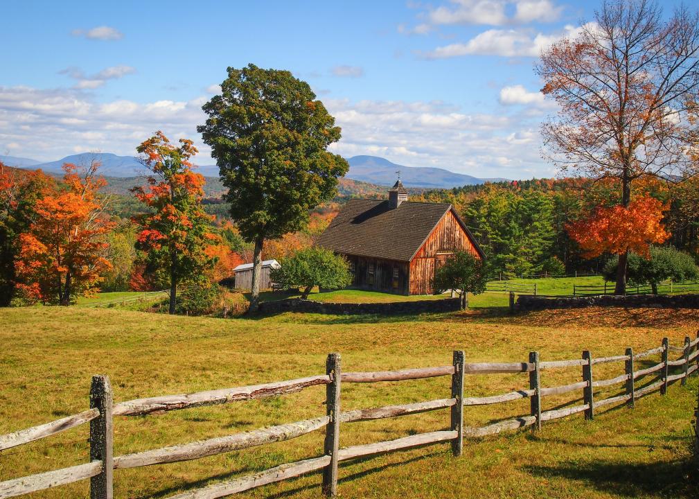 Rural landscape with split rail fence and barn in autumn.