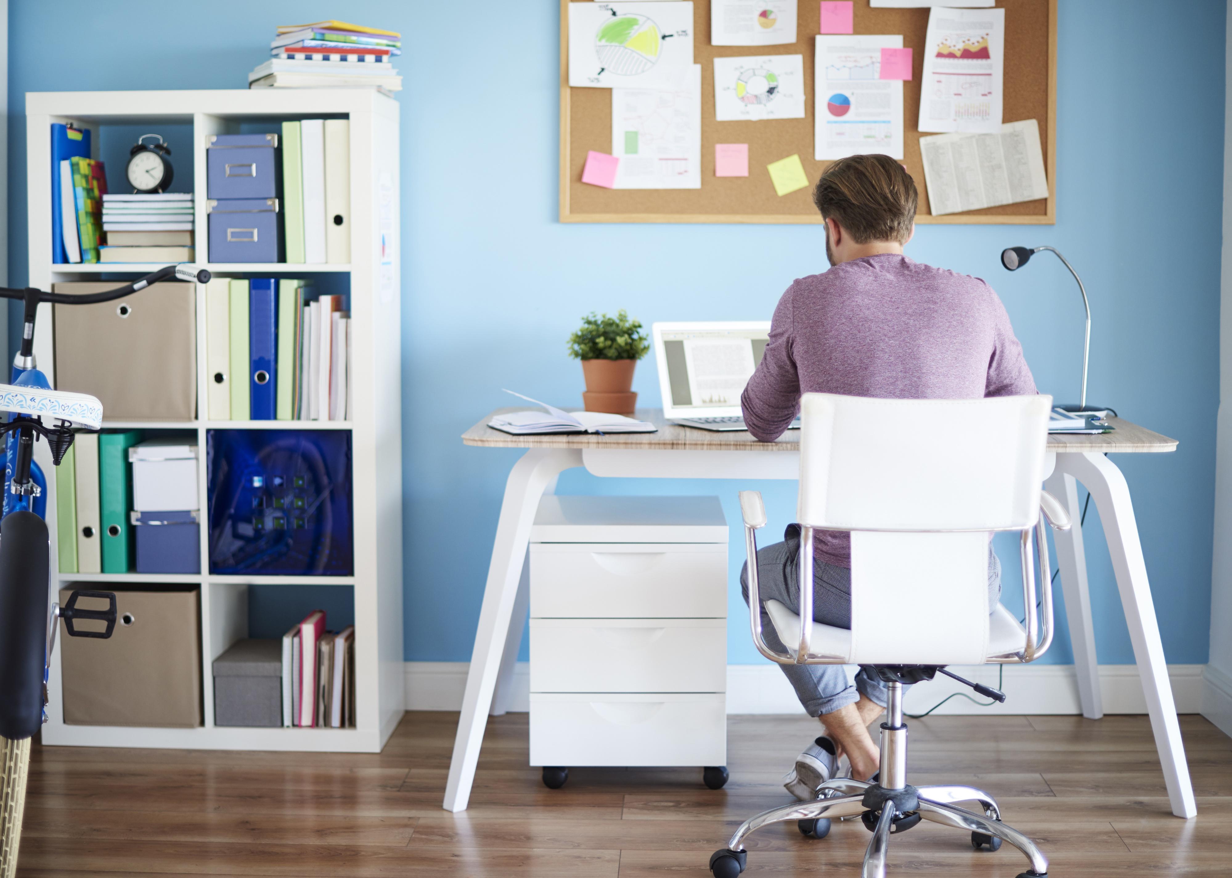 Rear view of a man at his desk at home