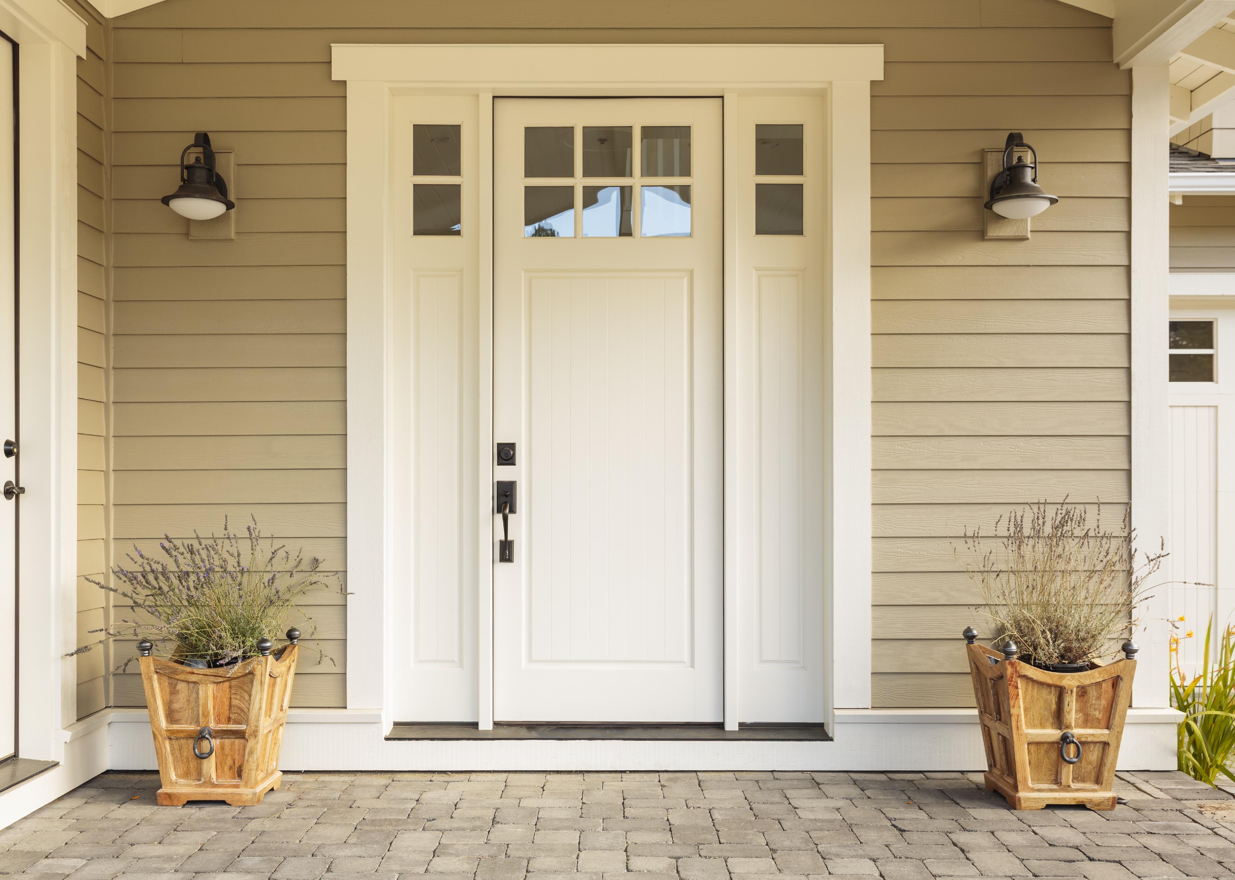 White front door with small square decorative windows.
