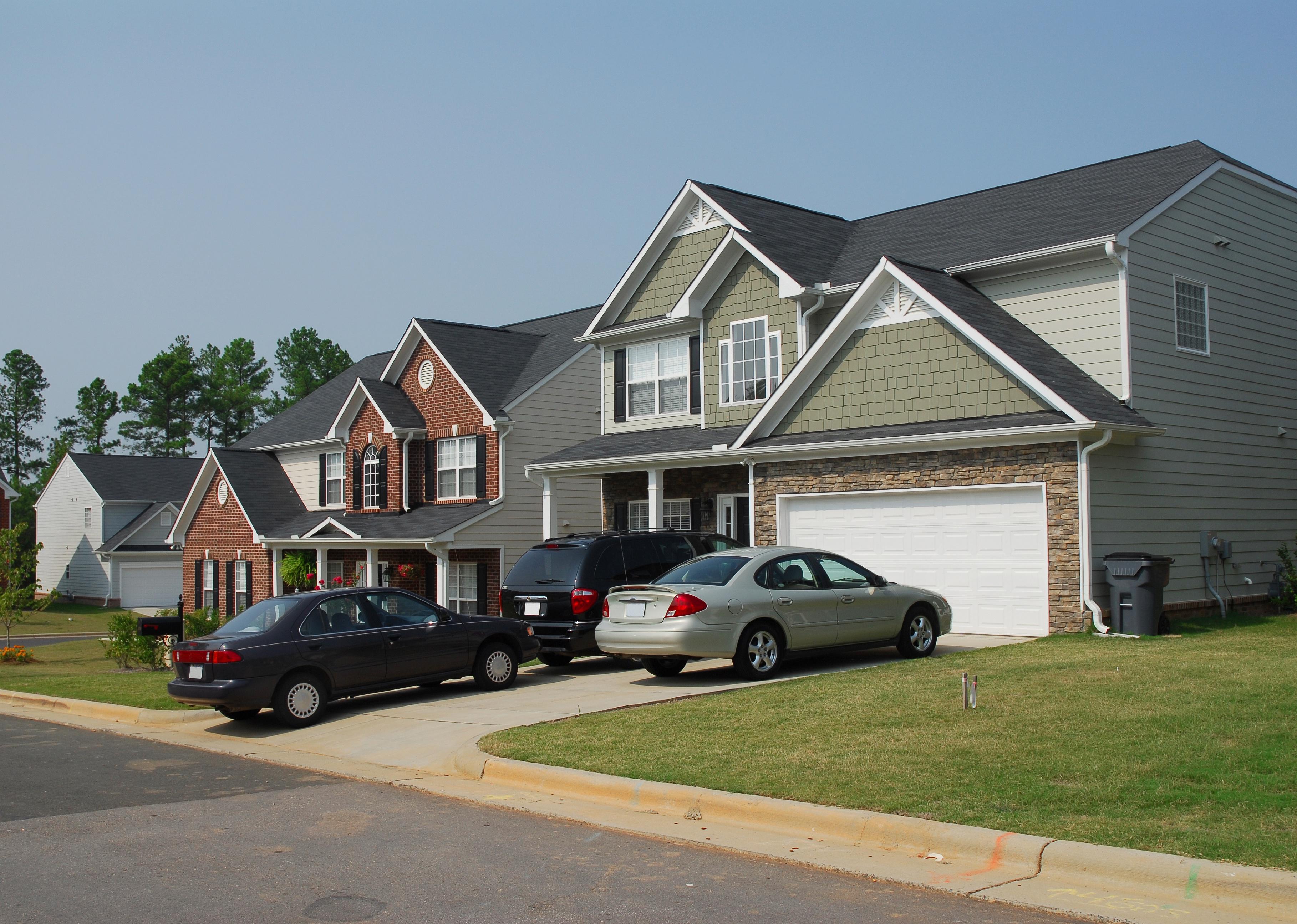 Modern residential houses with cars in the driveway.