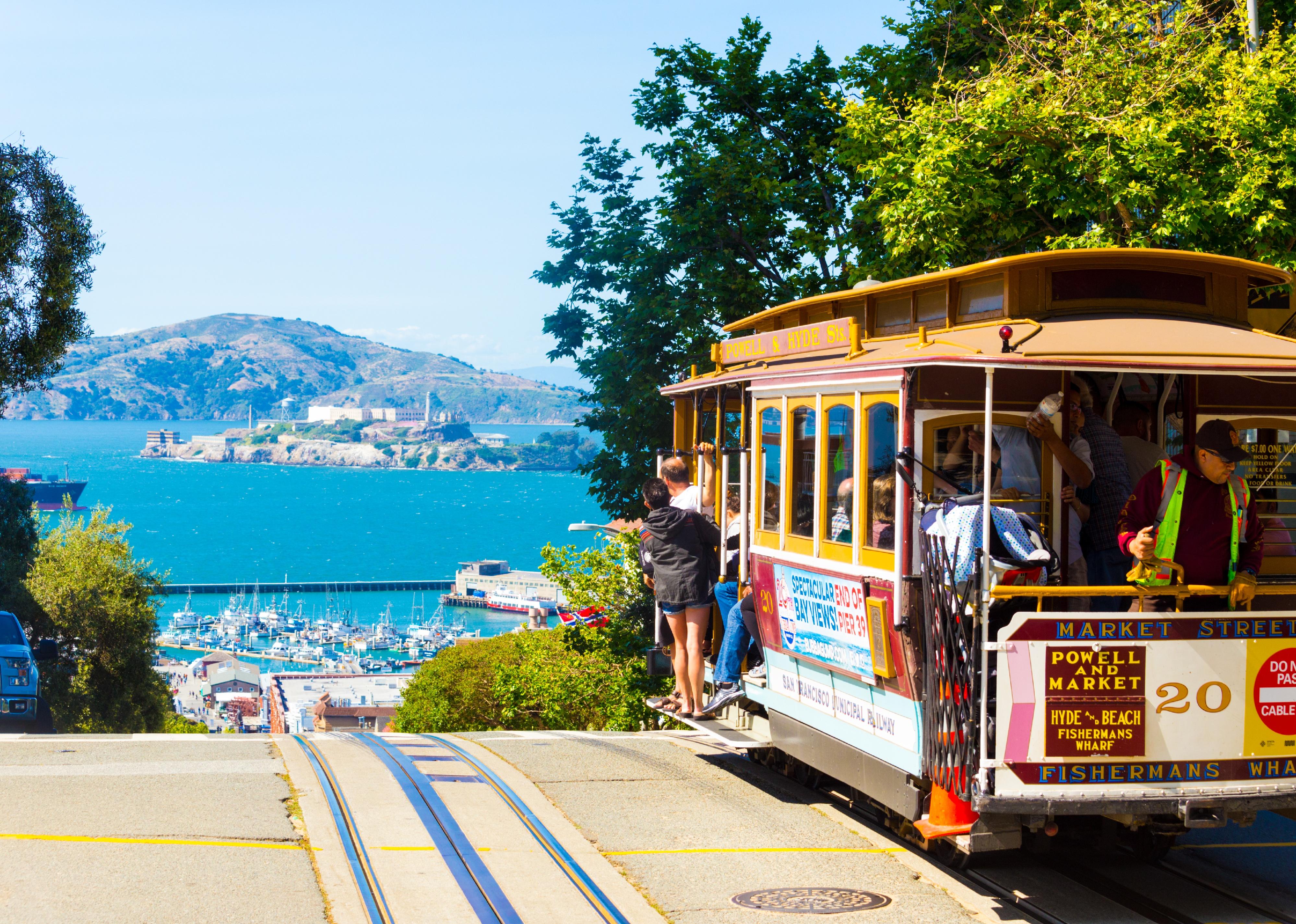 A cable car full of tourists at the peak of Hyde Street