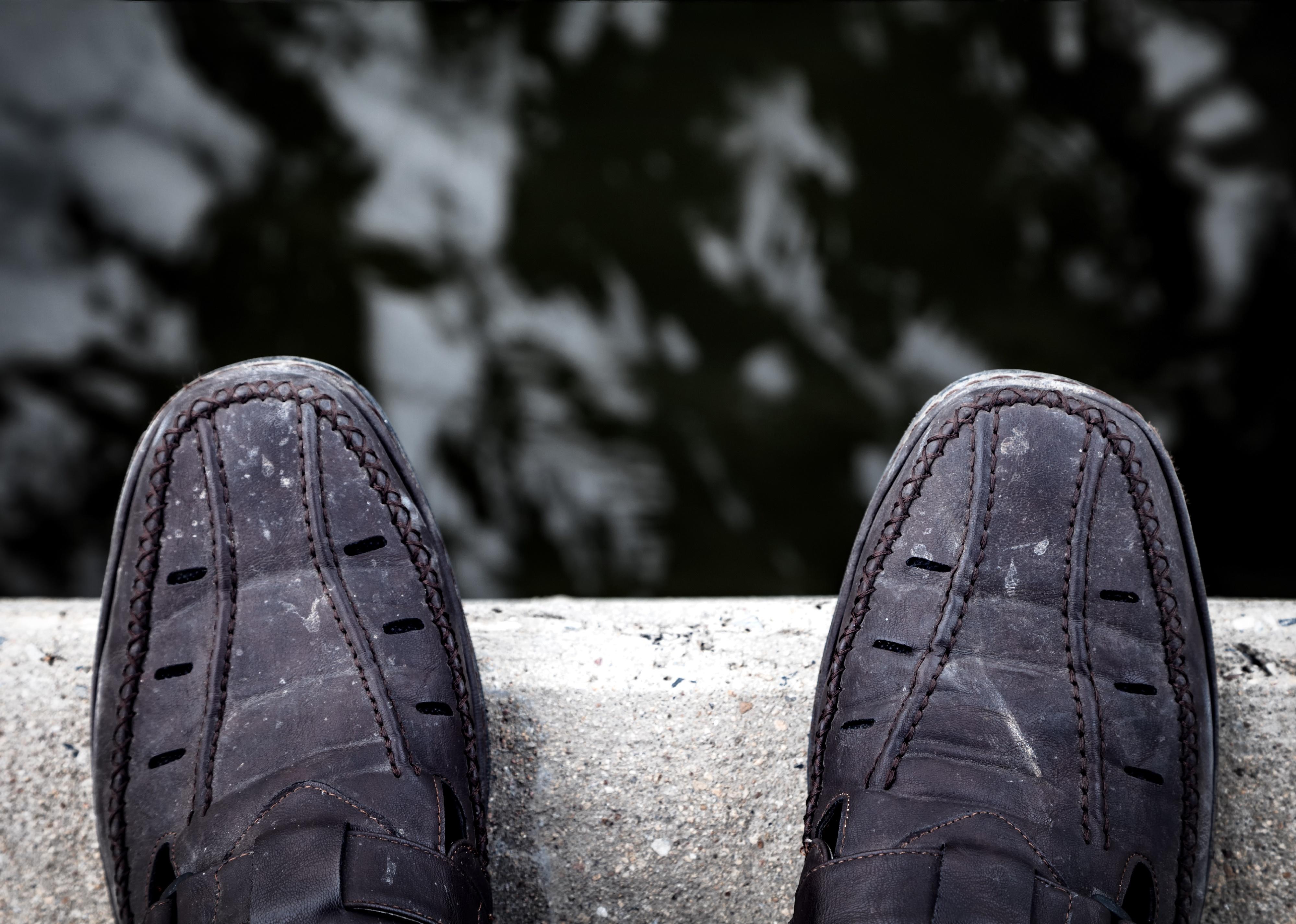 Person looking down at his shoe on a bridge.