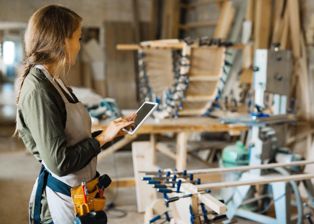 Woman with tablet looking at carpentry