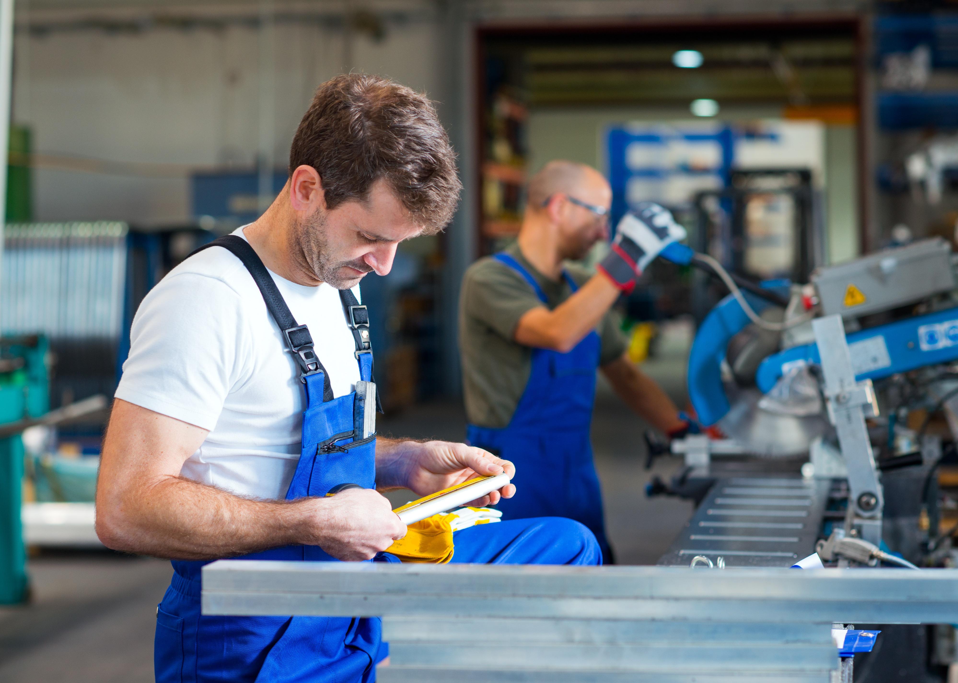 Men working on manufacturing equipment.