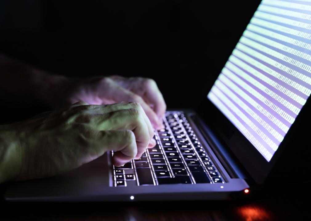 Close-up of a person's hand typing on a laptop.