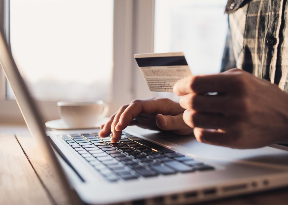 Man holding credit card and using laptop