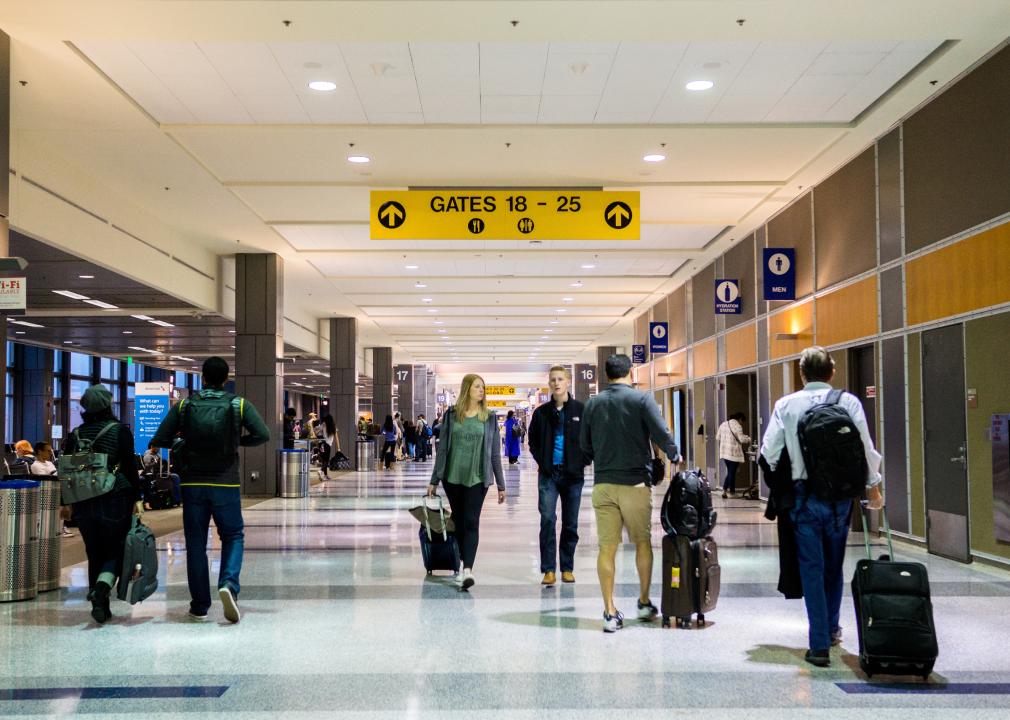 Travelers walk through an airport terminal at the Bergstrom International airport.
