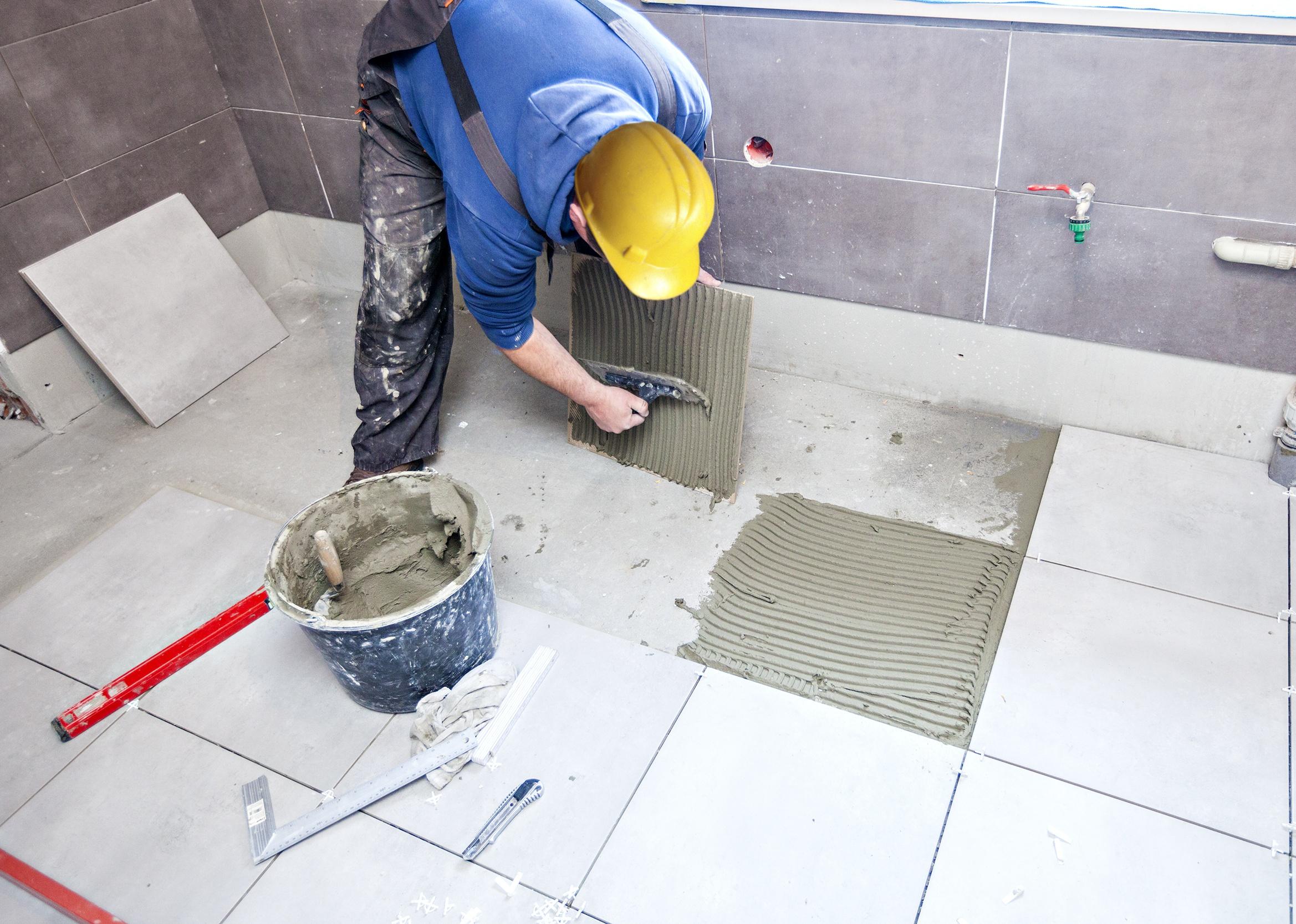 A tiler builder arranges the bathroom ceramics.