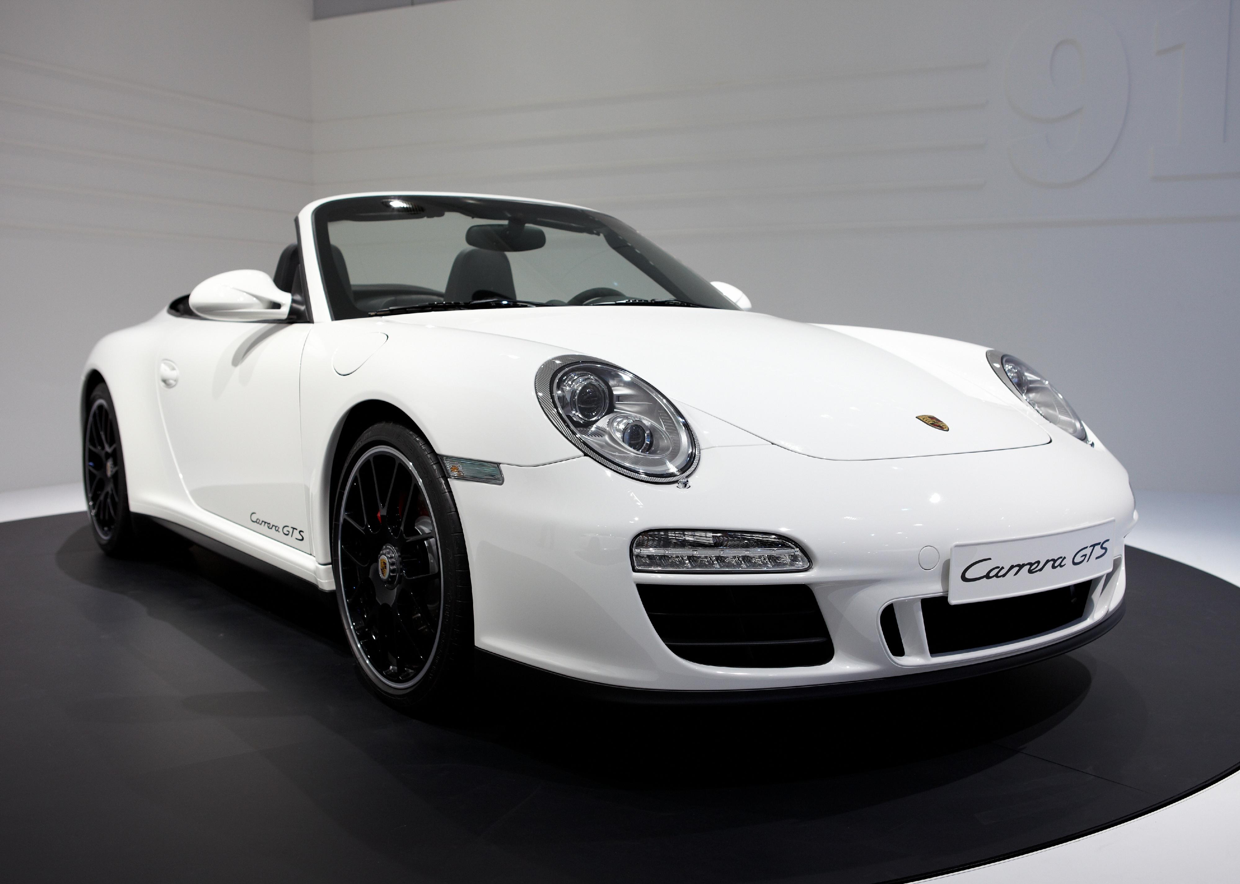 A white Porsche 911 Carrera GTS Cabriolet on display. 