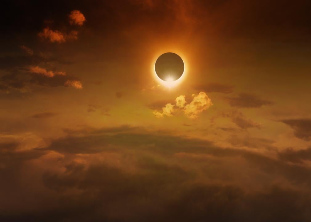 A total solar eclipse in a dark red glowing sky.