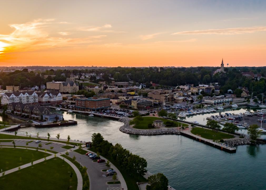An aerial view of a river running through town at sunset.