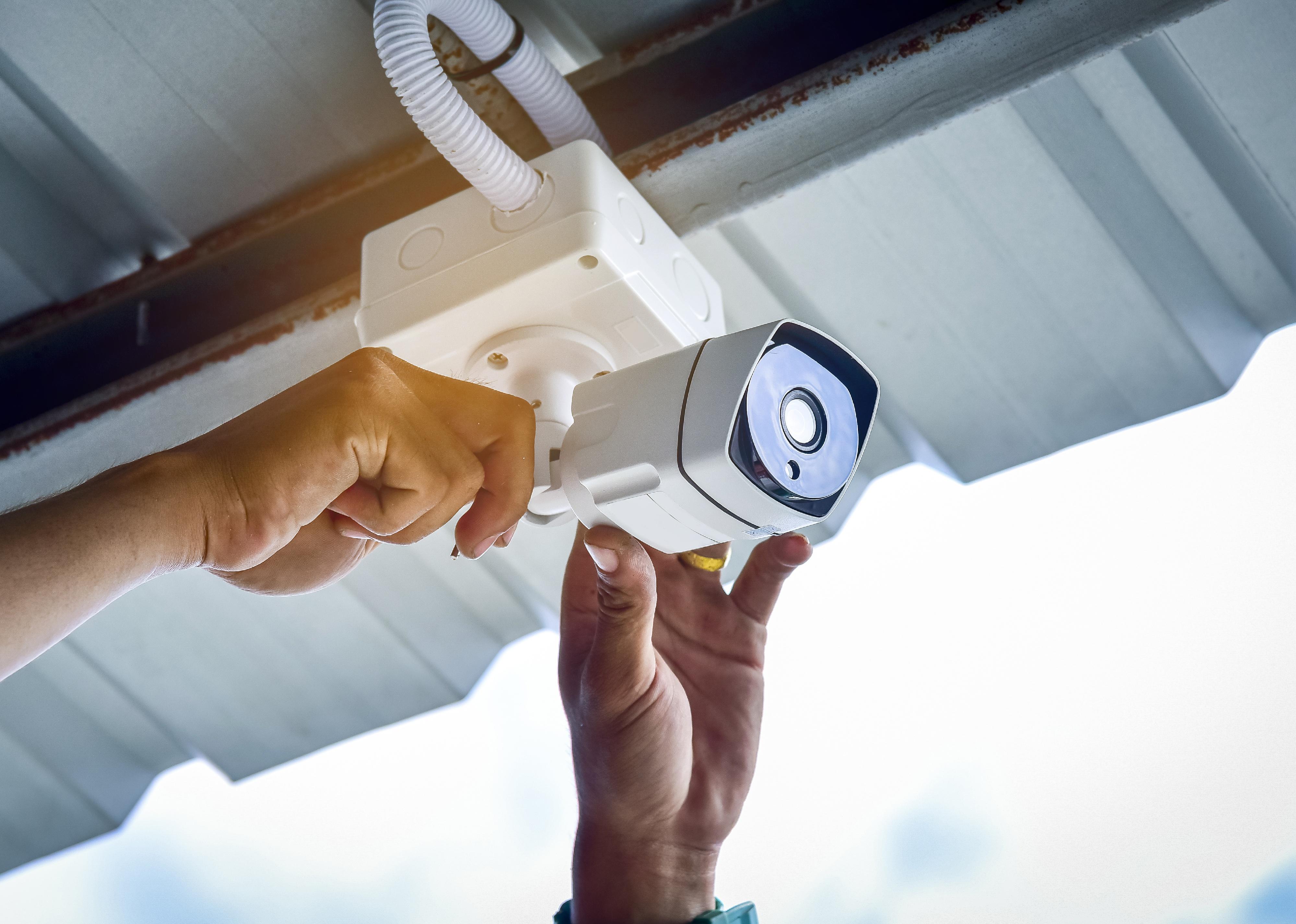 Technician installing CCTV camera security system.