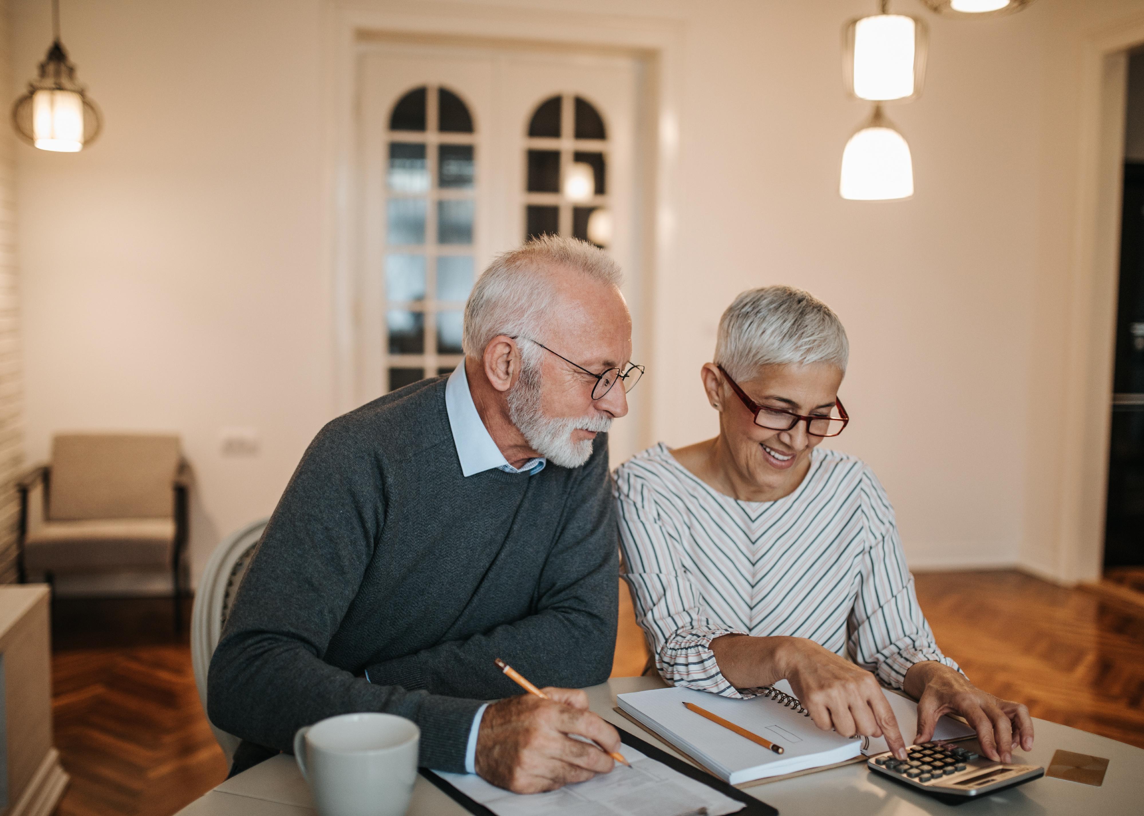 Senior couple sitting at table doing finances.