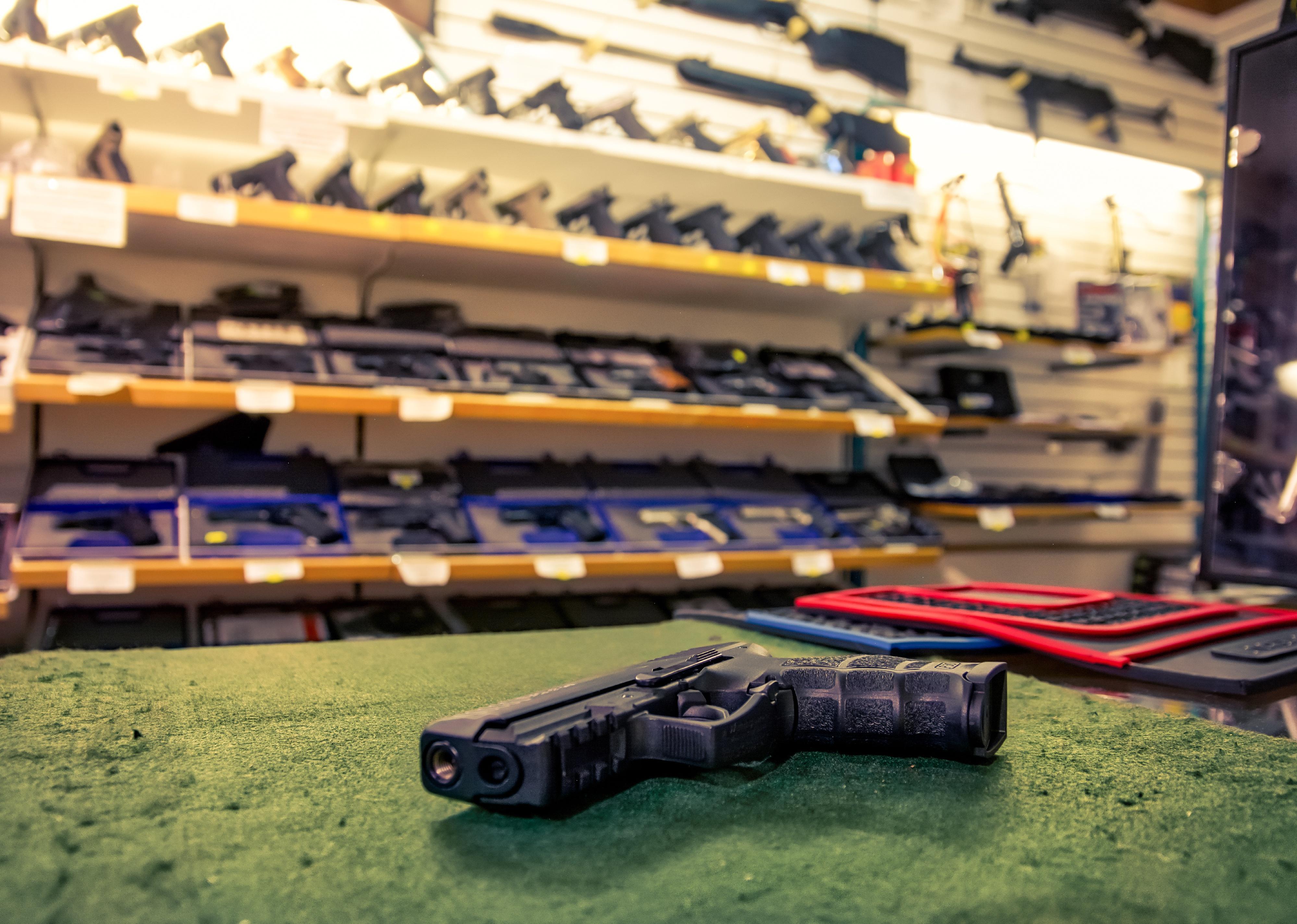 Black pistol gun on store countertop.