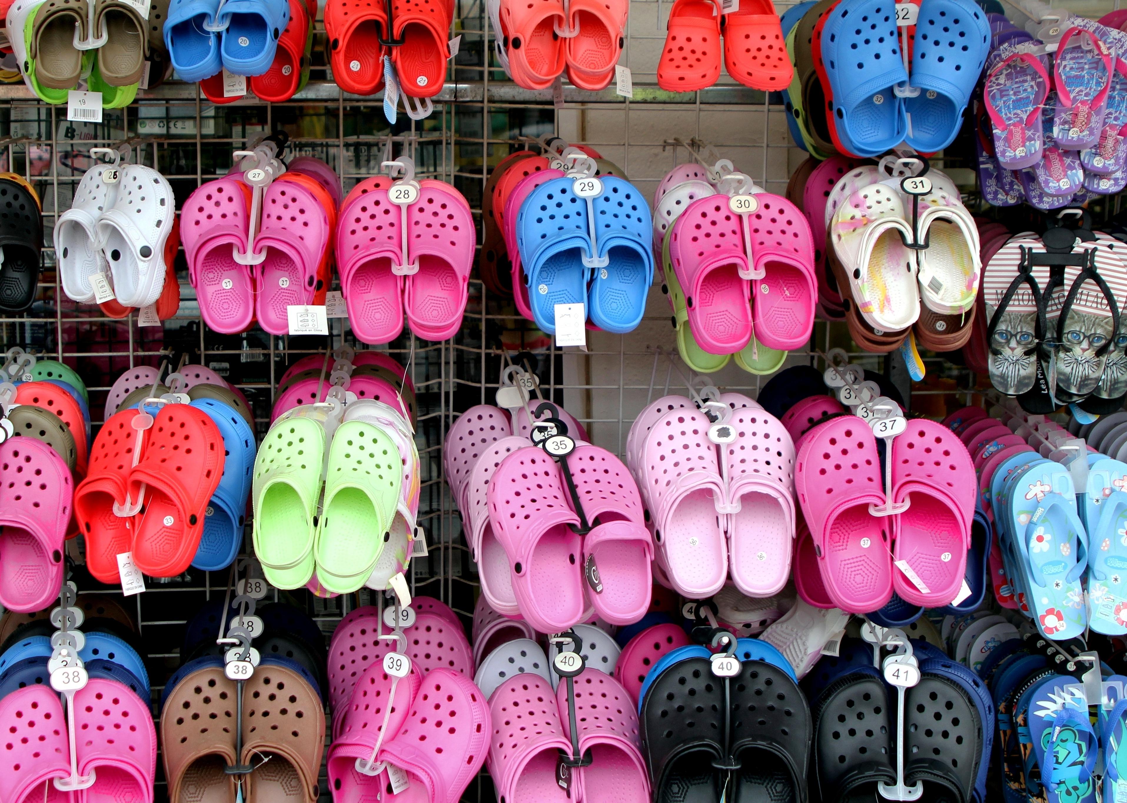 Display of soft plastic Crocs shoes on display.