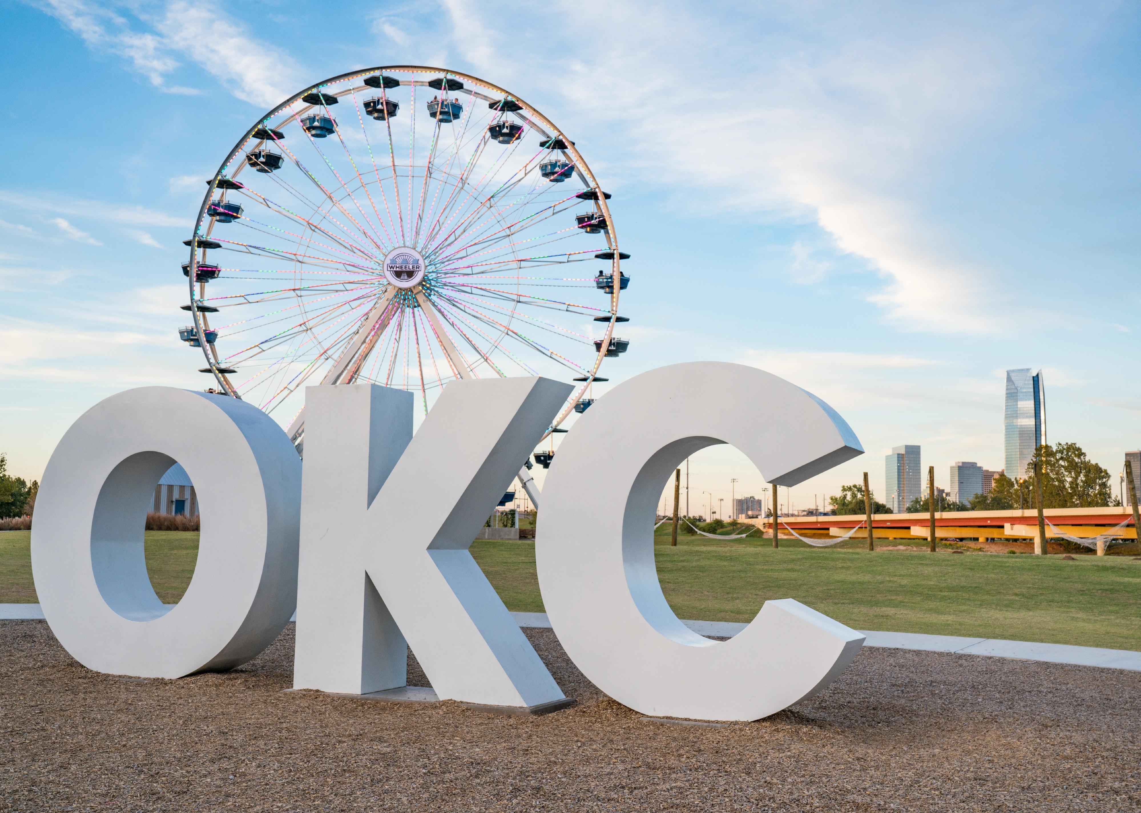 Skyline of Oklahoma City with OKC sign and ferris wheel.