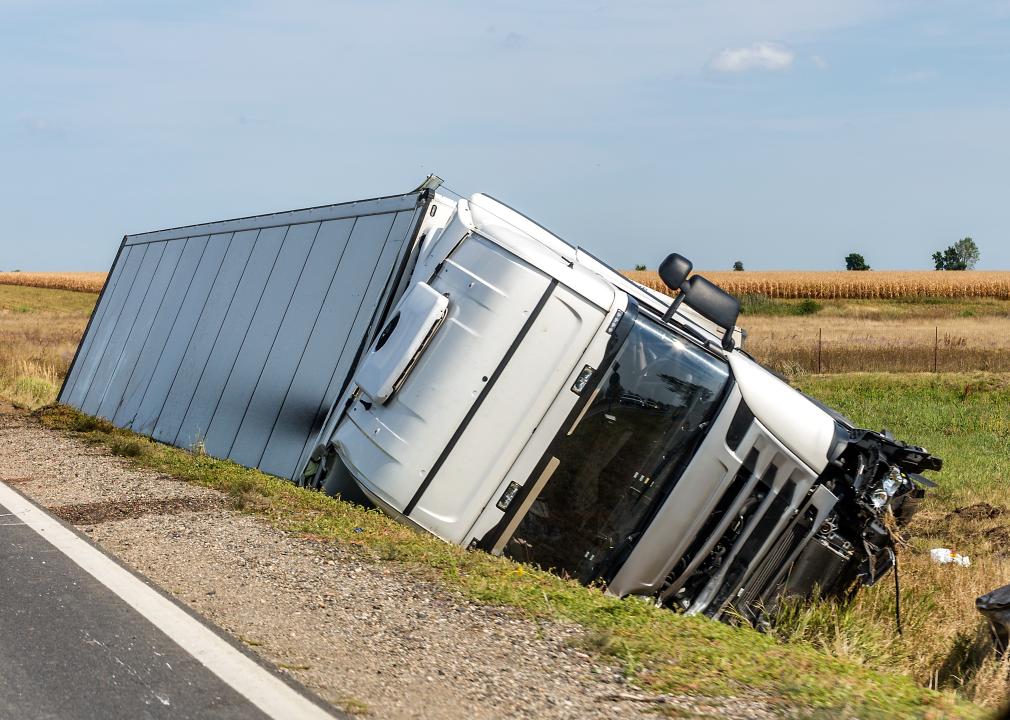 Large truck lies in a side ditch after a road accident