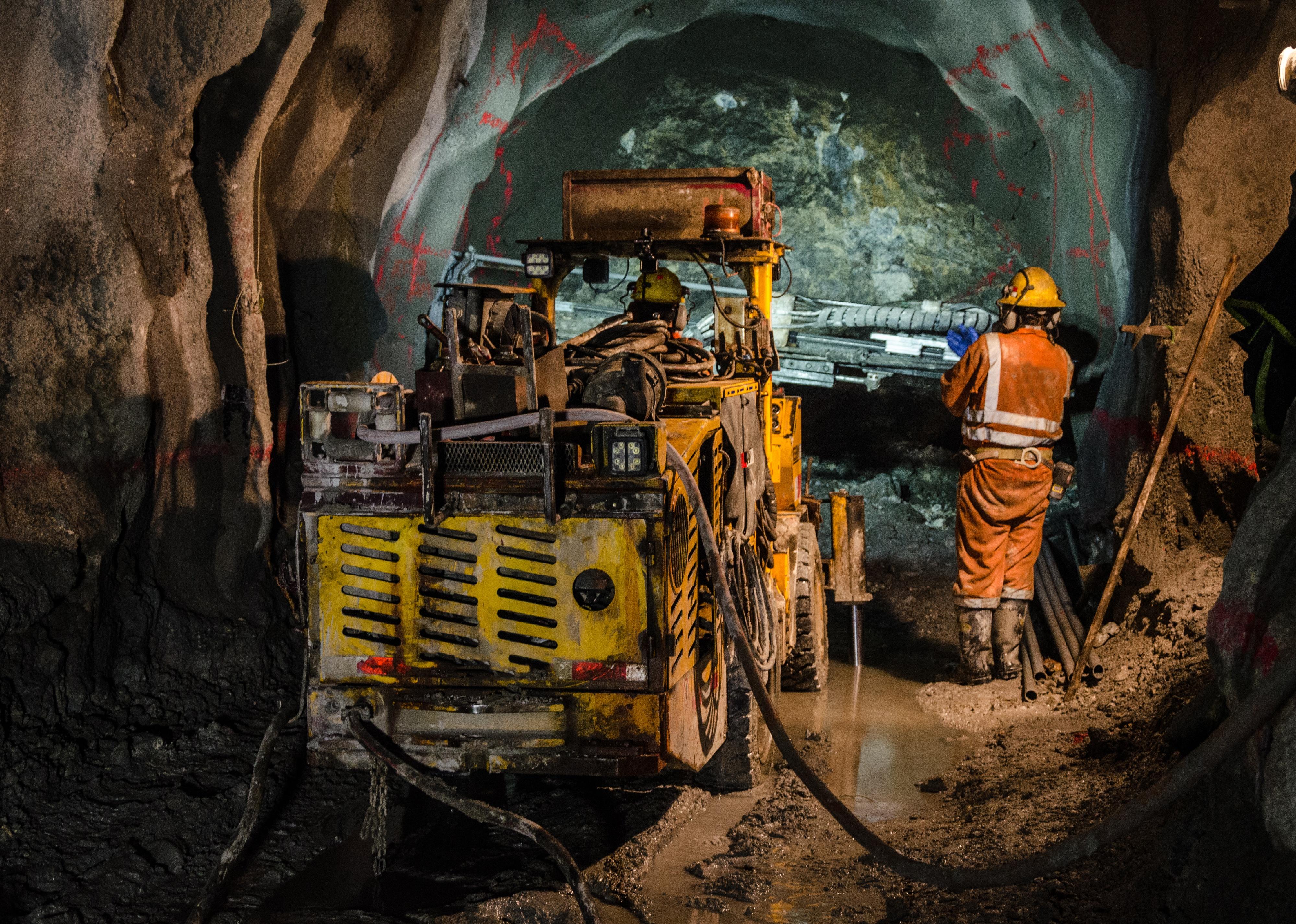 Workers operate heavy machinery in a mine.
