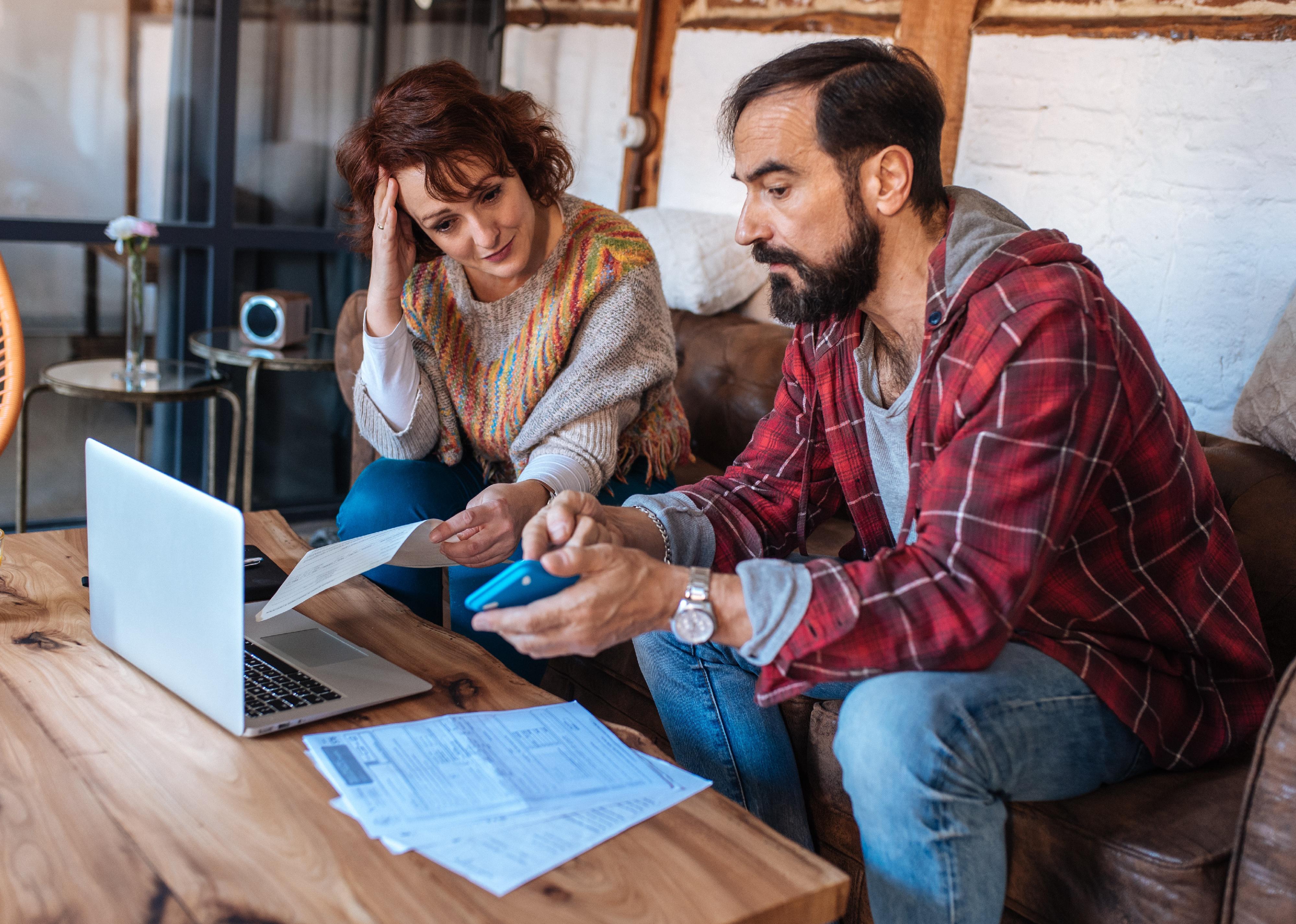 Mature couple sitting at home looking at their finances