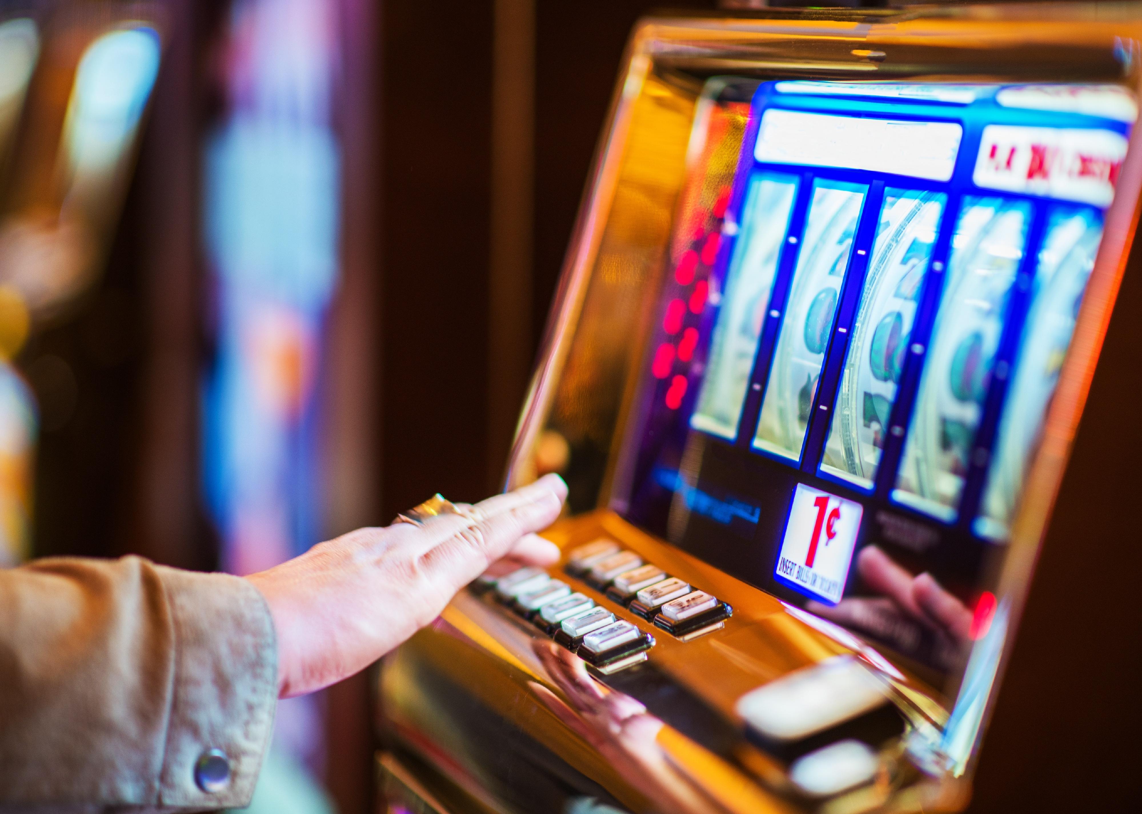 Person's hands on slot machine.