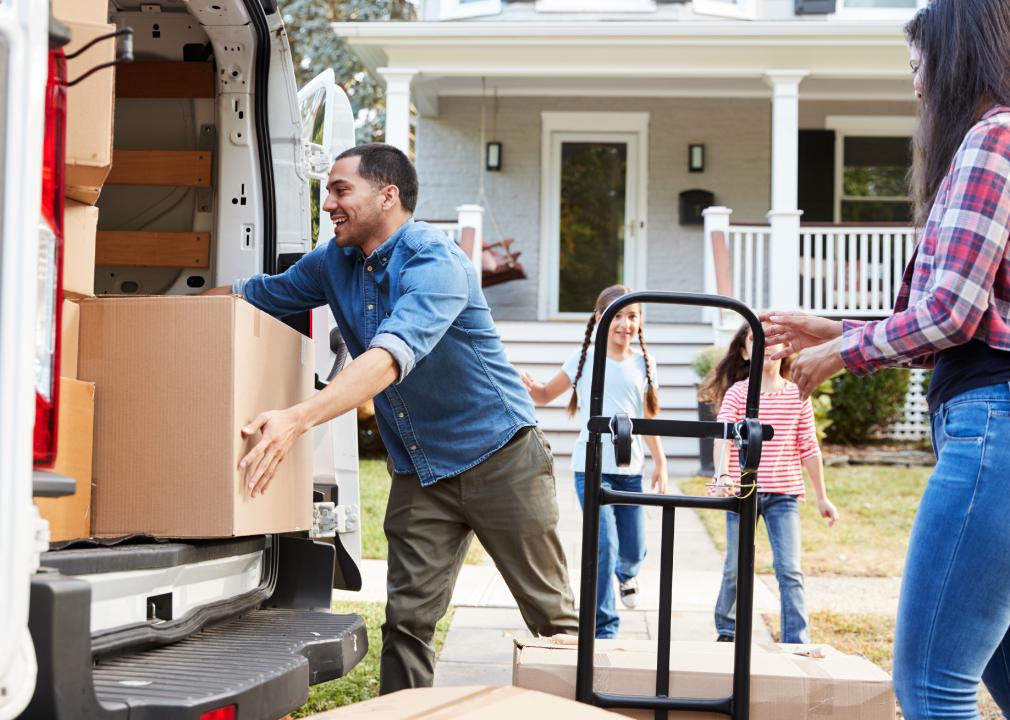 Family unloading movinf boxes from van