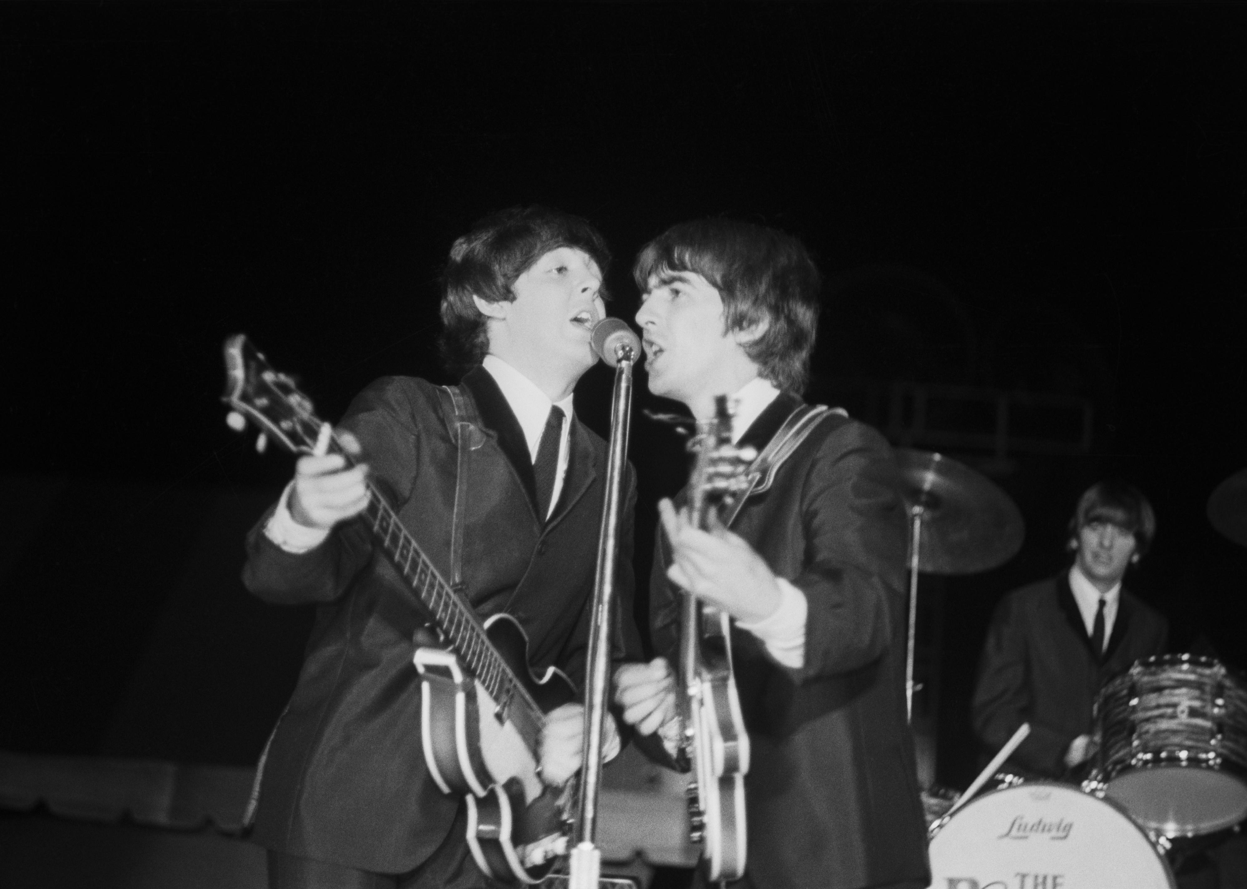 The Beatles performing onstage.