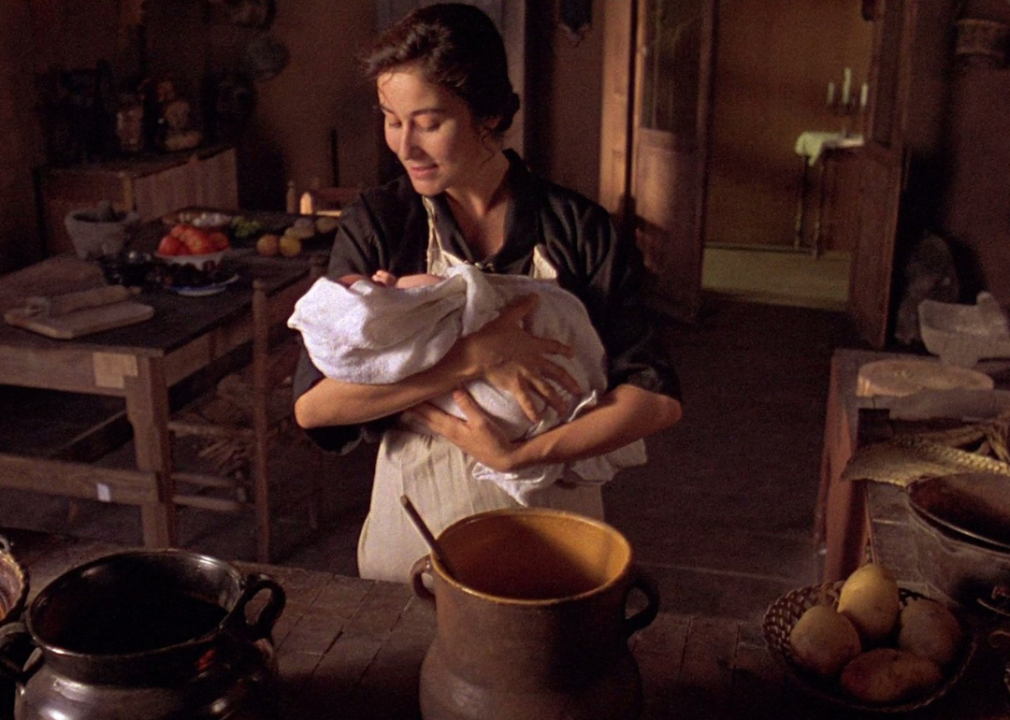 Lumi Cavazos holding a baby in a kitchen.