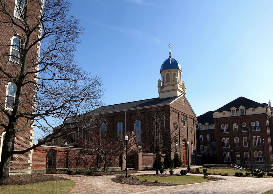 Several large dark red brick buildings with white trim and a clocktower.