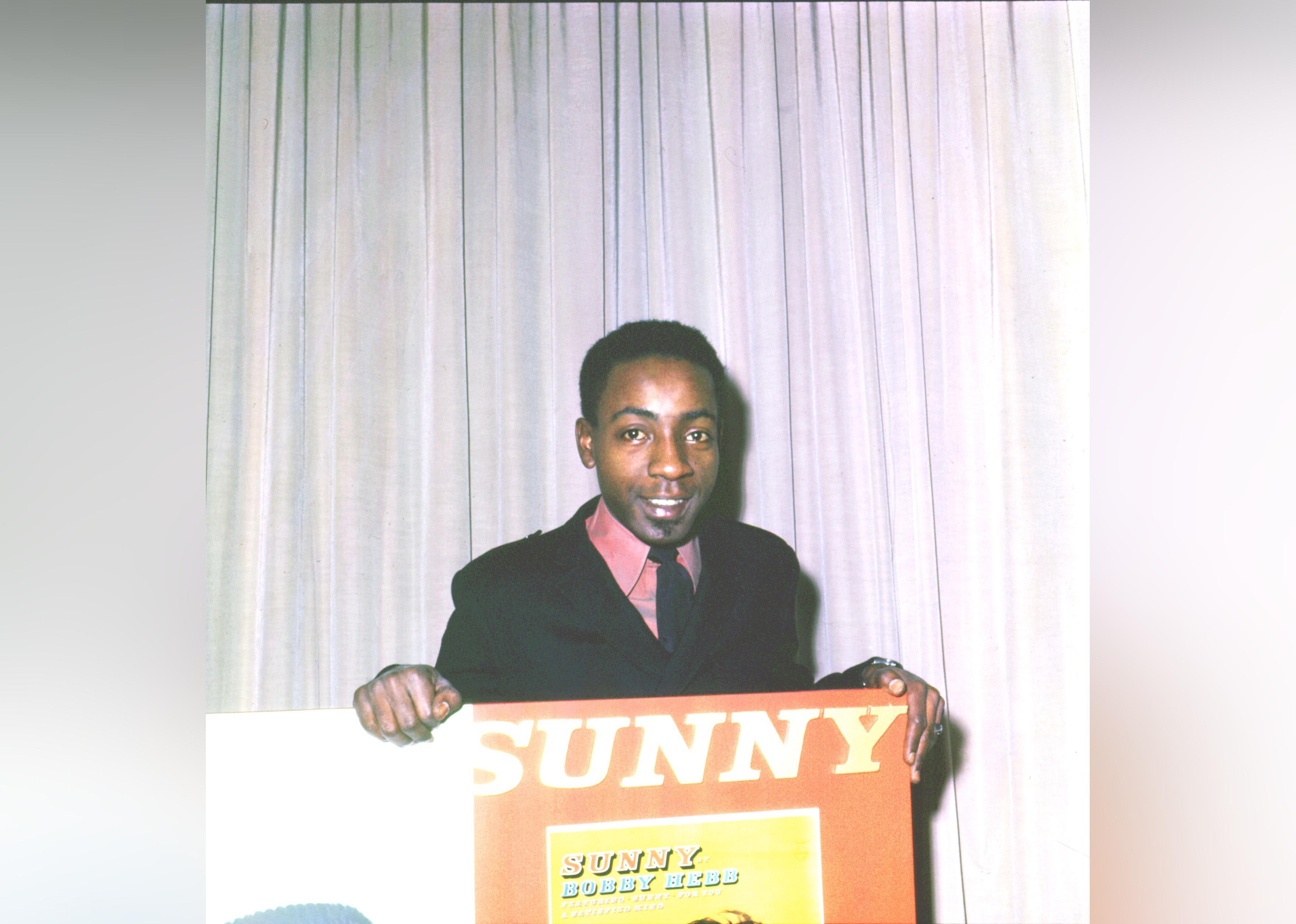 Bobby Hebb  holding a sign for the song 'Sunny'.