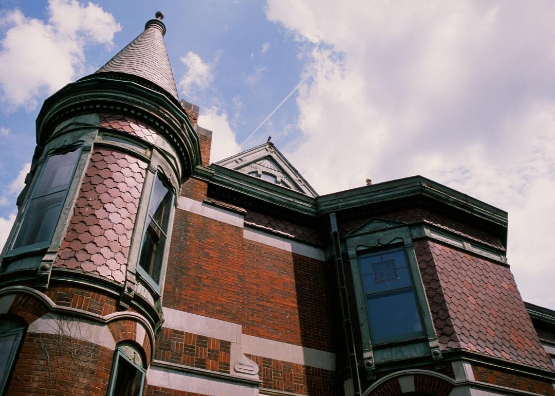 An old-style, red brick home under a blue sky.