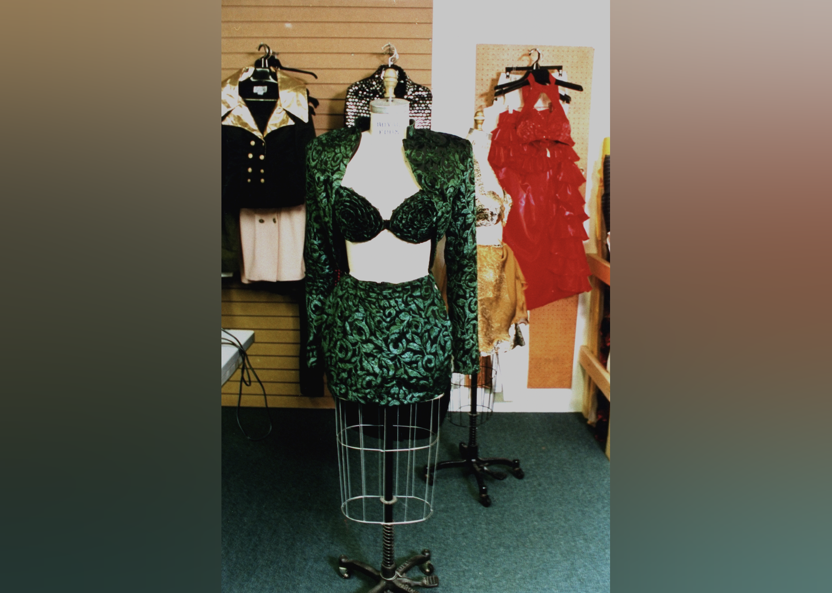 Crushed velvet green floral halter top, bolero jacket & miniskirt on dressmaker's dummy which was worn by late singer Selena.