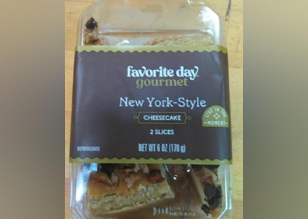 A plastic container with two slices of New York-Style cheesecake.