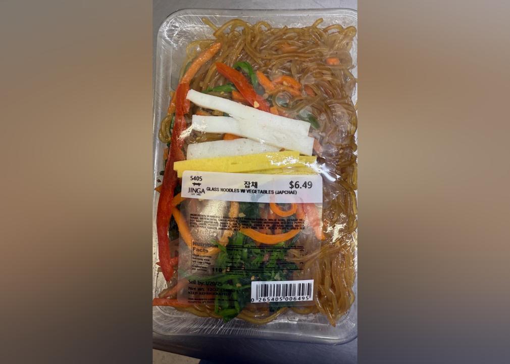 A tray of plastic-wrapped Jinga glass noodles with vegetables.
