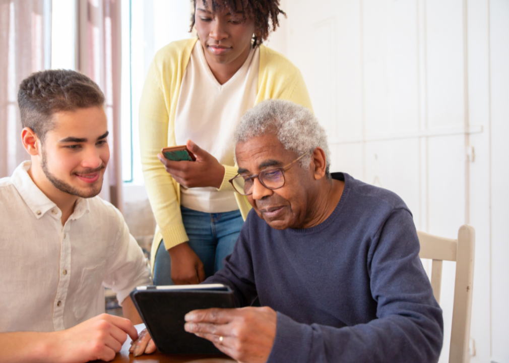 Two younger people helping an elderly man.