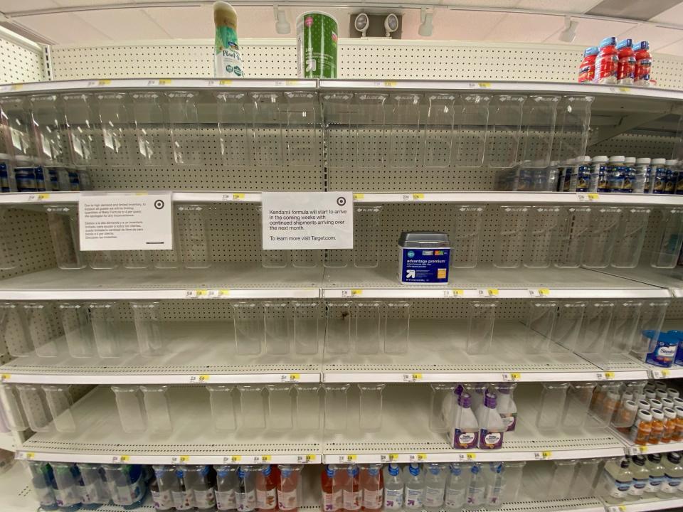 Empty shelves in the baby formula aisle at Target with a note taped to a shelf saying there are shipments expected in the coming weeks and months.