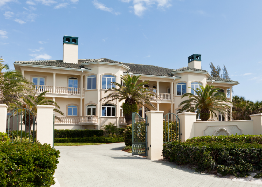 A large home with palm trees in the front.