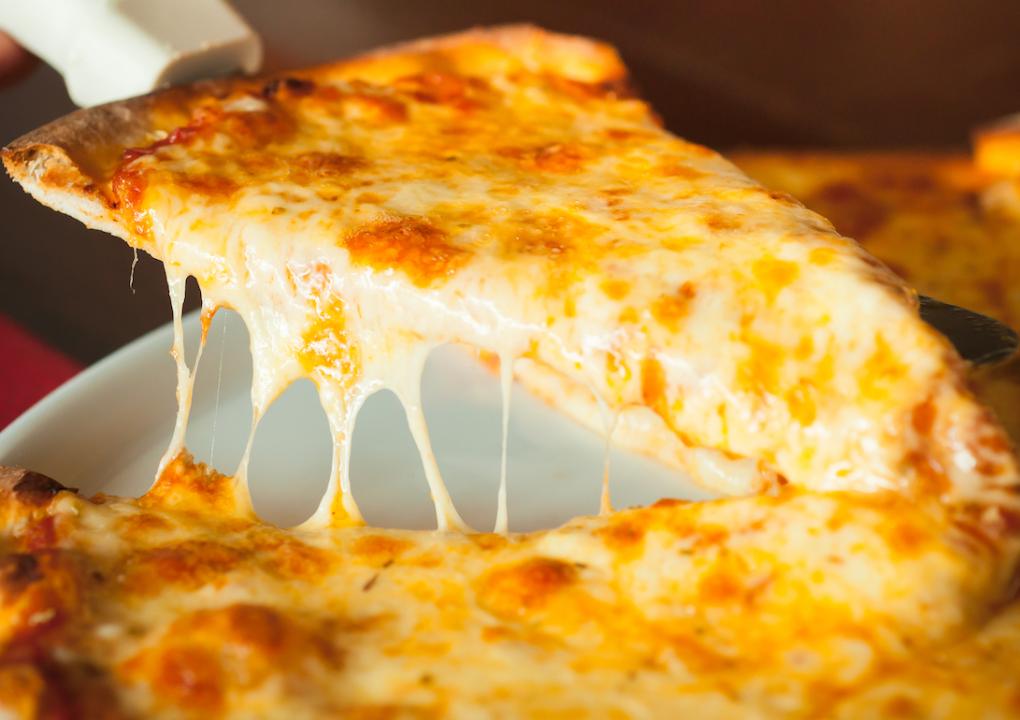 Four-cheese pizza slice being pulled from a pie.