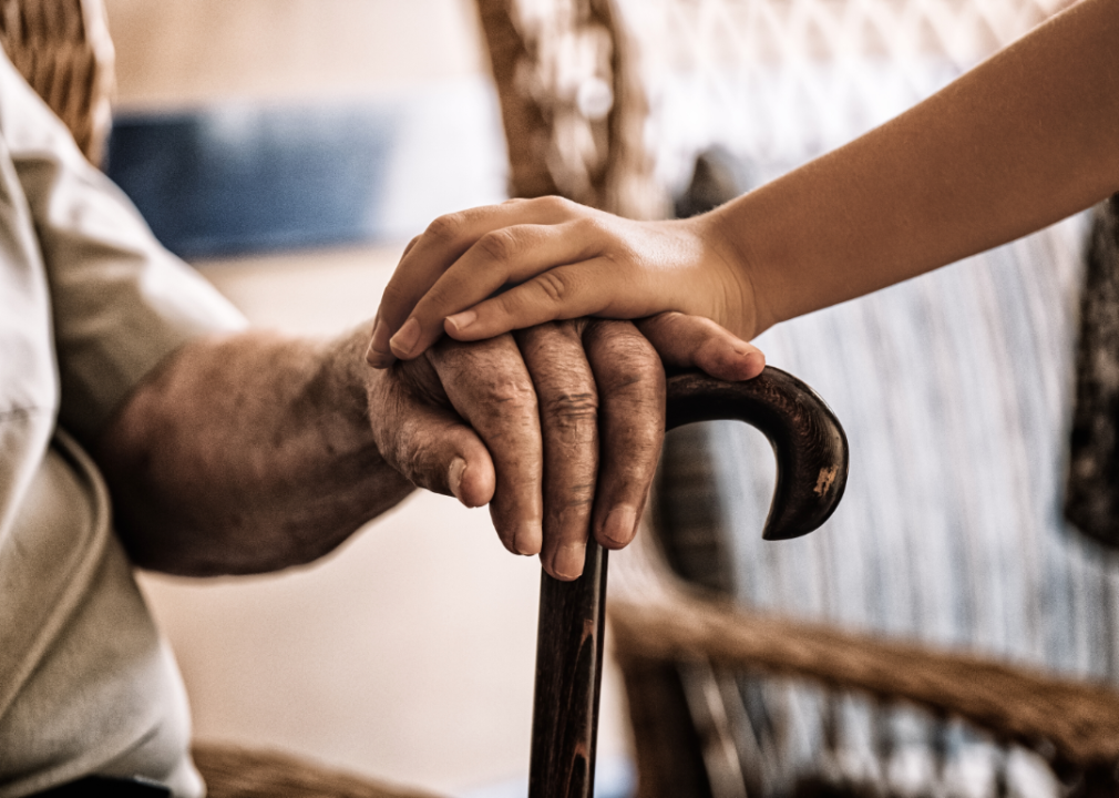 A young person's hand on top of an elderly hand.