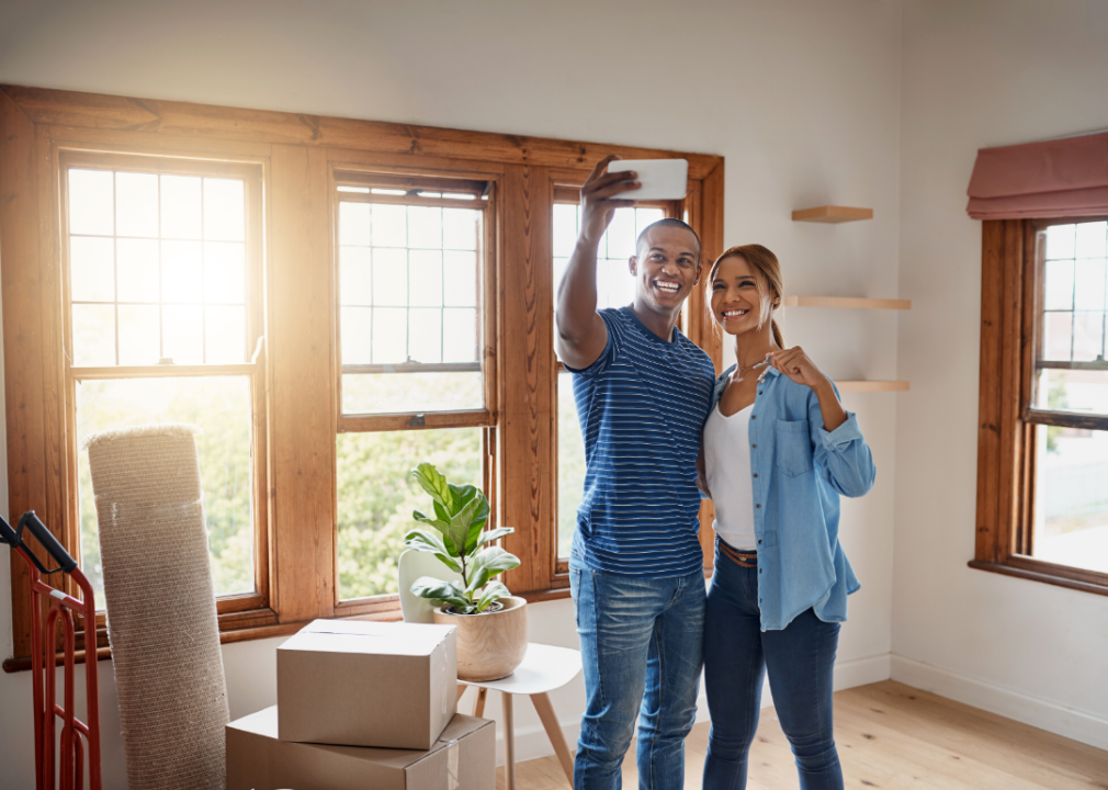 A young couple taking a selfie as they move into a new home.