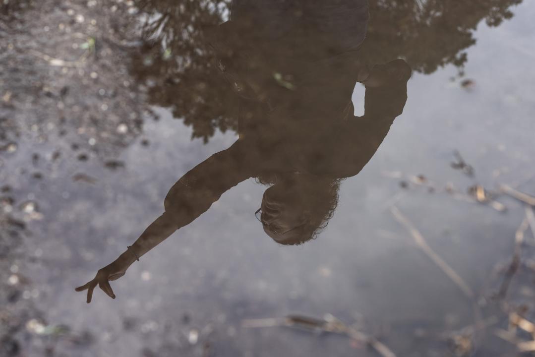 Ana Zimmerman, reflected in standing water, near the site of her old home in Shoreham Road.
