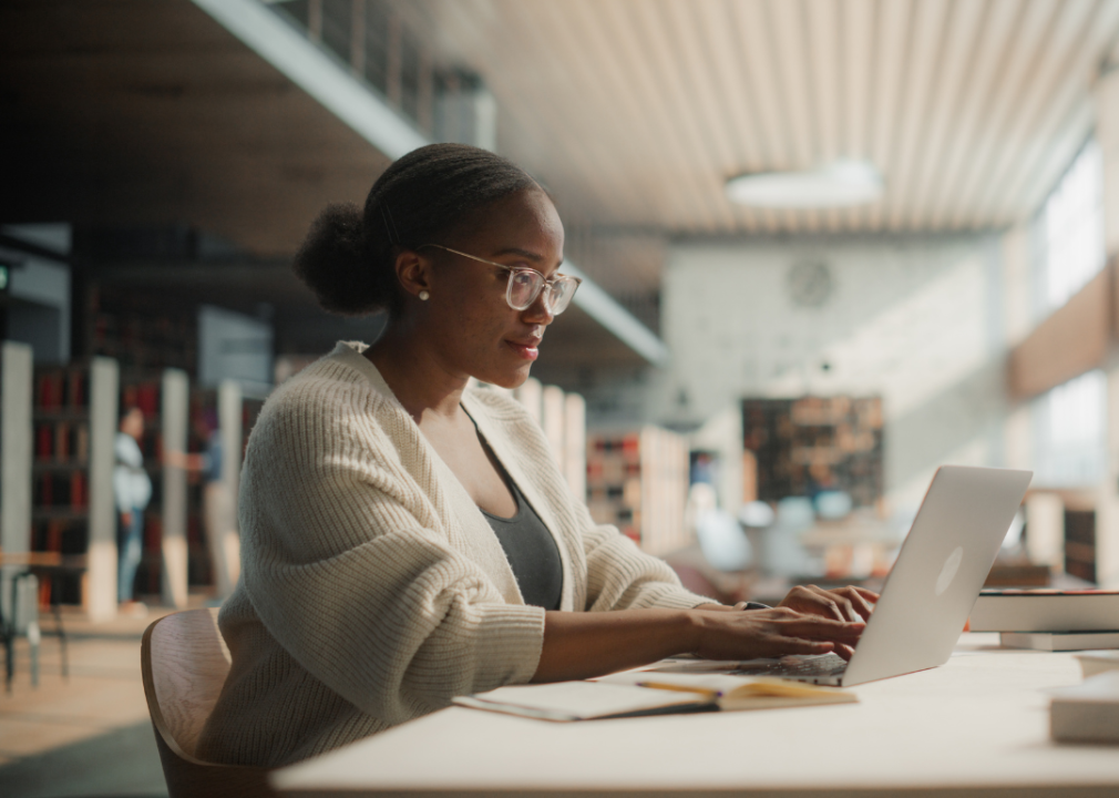 A student on a laptop in a library.