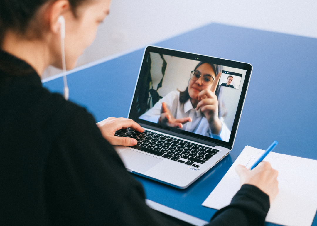 Two women on a video call itemize a list.