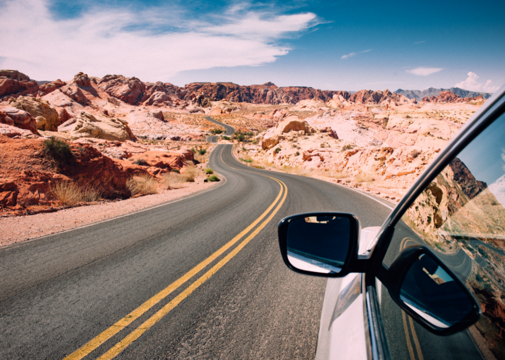 A car driving through the desert and mountain scenery in Nevada.