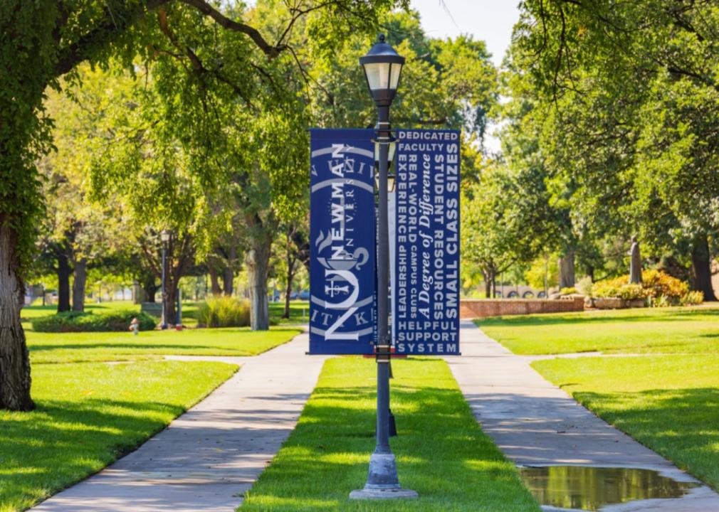 A blue Newman University sign on campus.