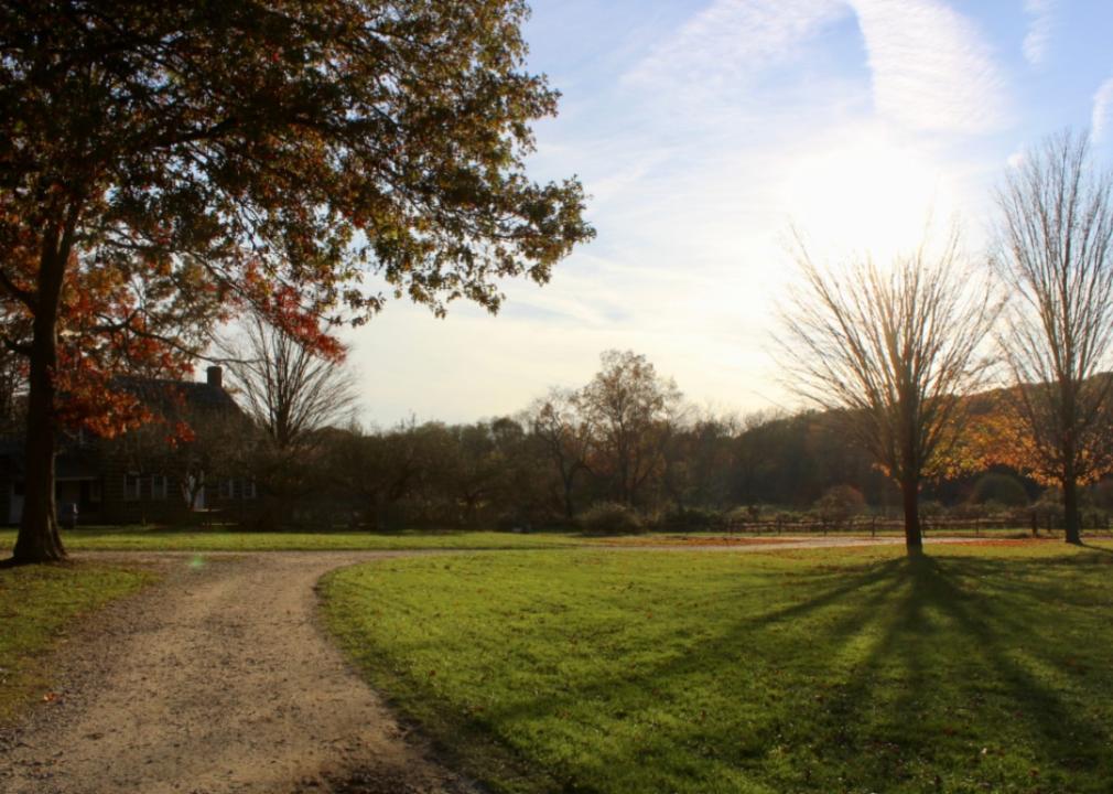 A dirt path leading to a nice home in the country.