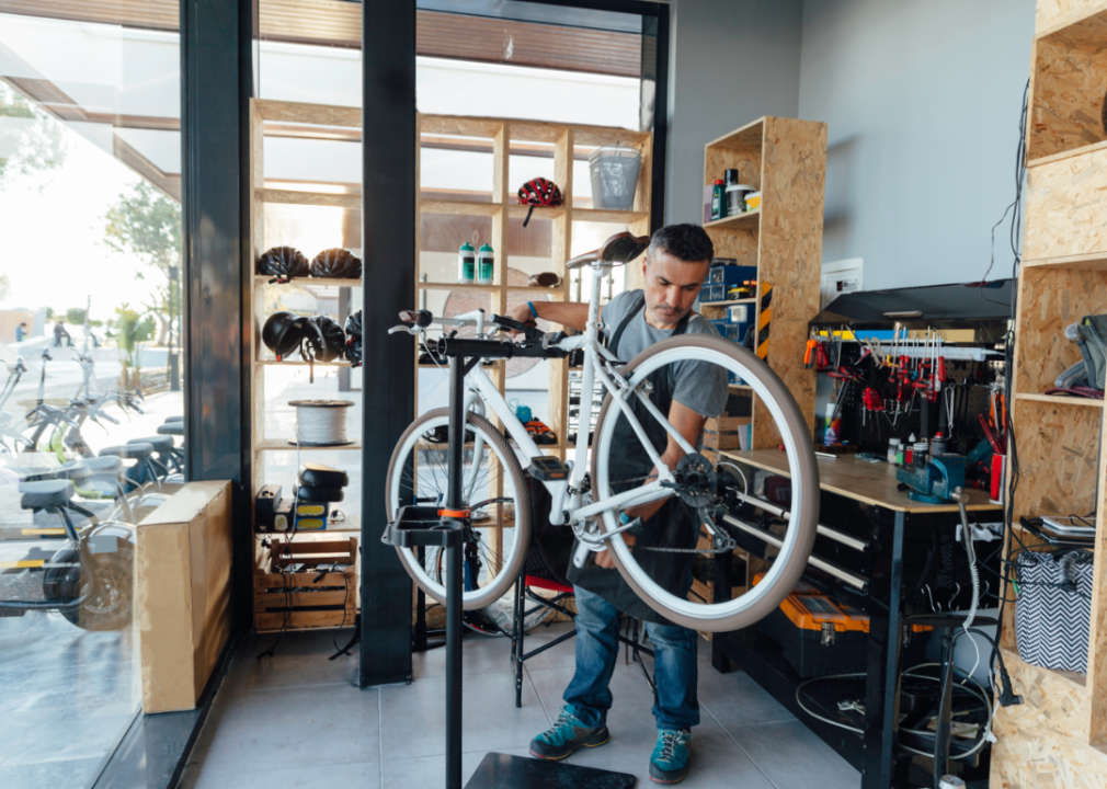 A person in a trendy looking bike shop works on a bike.