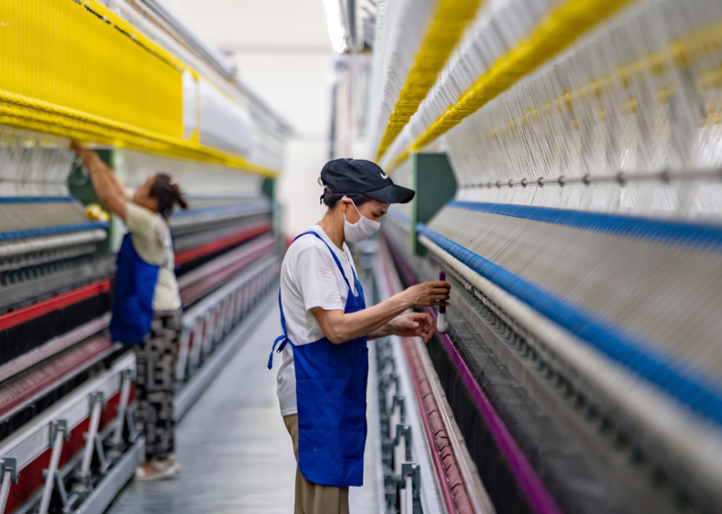 A couple of people working in a polyester fabric factory.